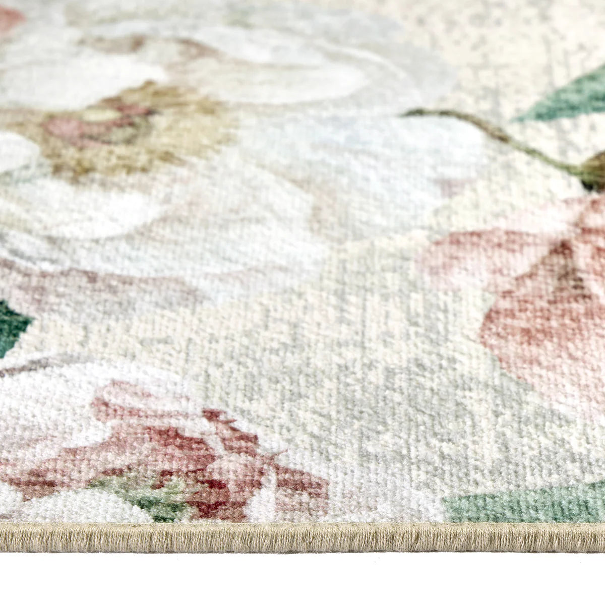 Close-up of a floral-patterned rug with pink flowers and green leaves on a white background.