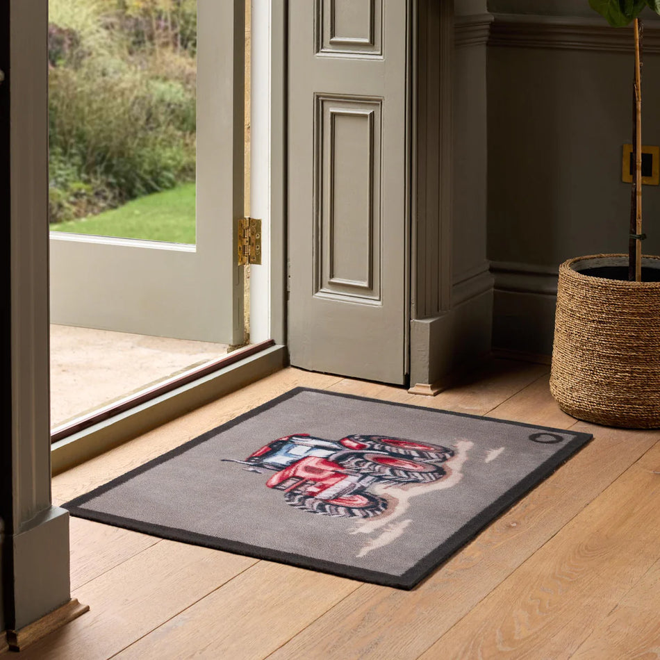 Doormat with a tiger design on a wooden floor in front of a door.