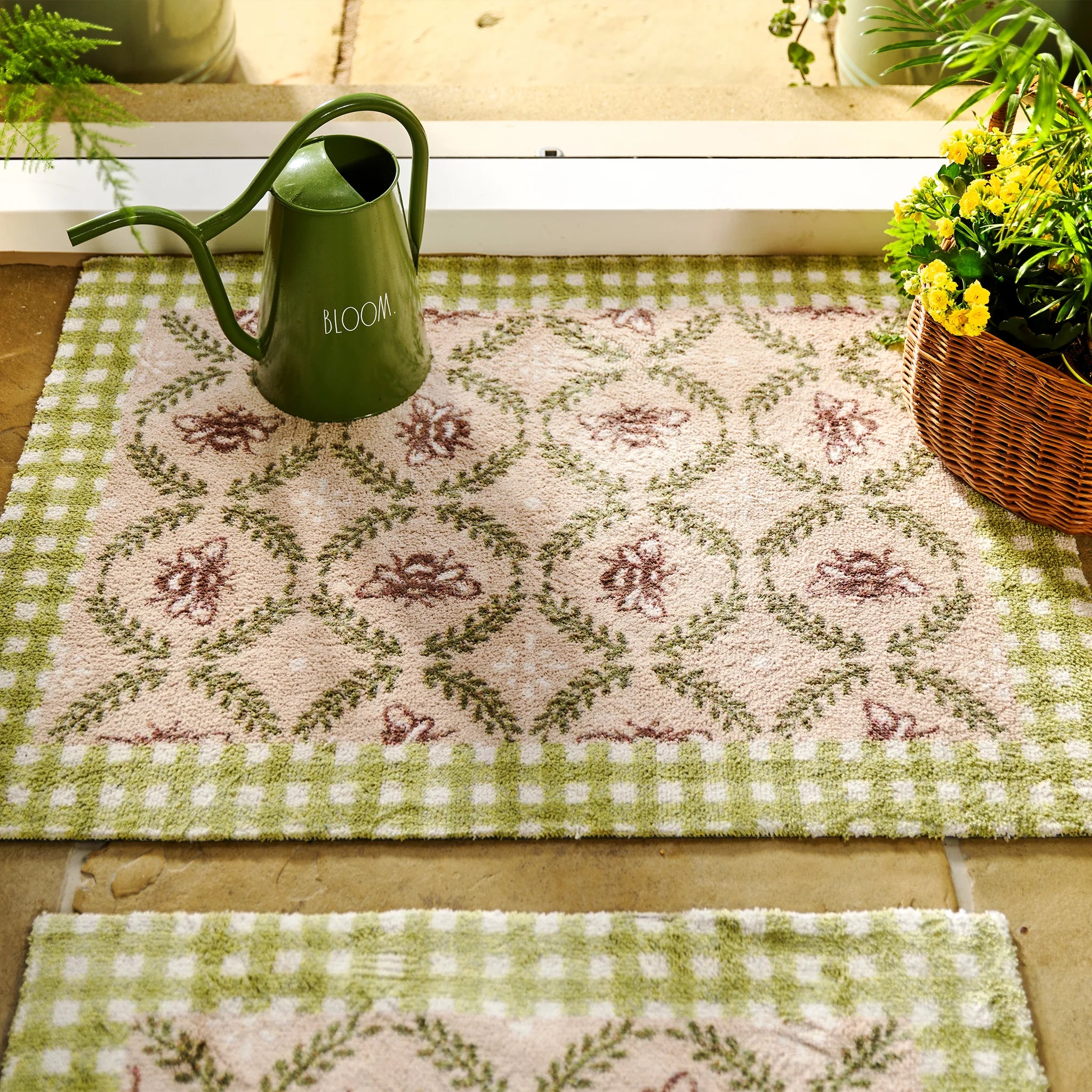 Decorative green and white checkered rug with floral patterns, accompanied by a green watering can and potted plants.