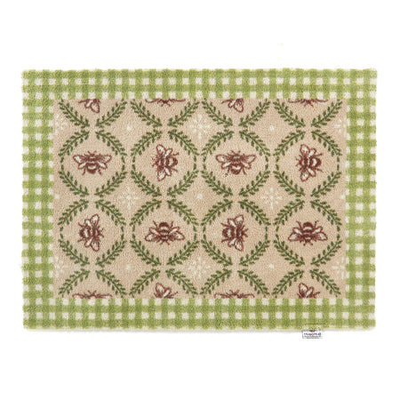 Decorative doormat with floral pattern and green border on a white background