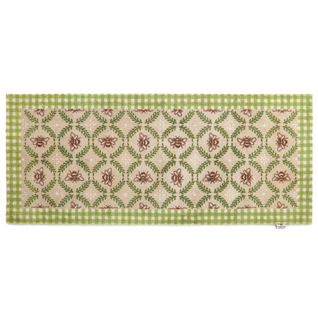 Decorative floor runner with green and beige pattern on a beige bee hive background
