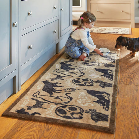 Child playing with a dog on a decorative rug in a home setting