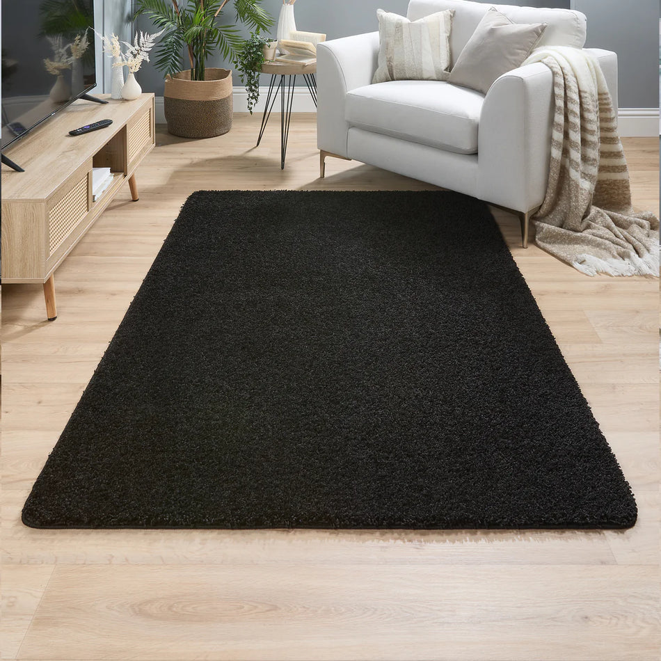 my rug My Rug Charcoal rug on a wooden floor in a living room setting with a white sofa and wooden coffee table.
