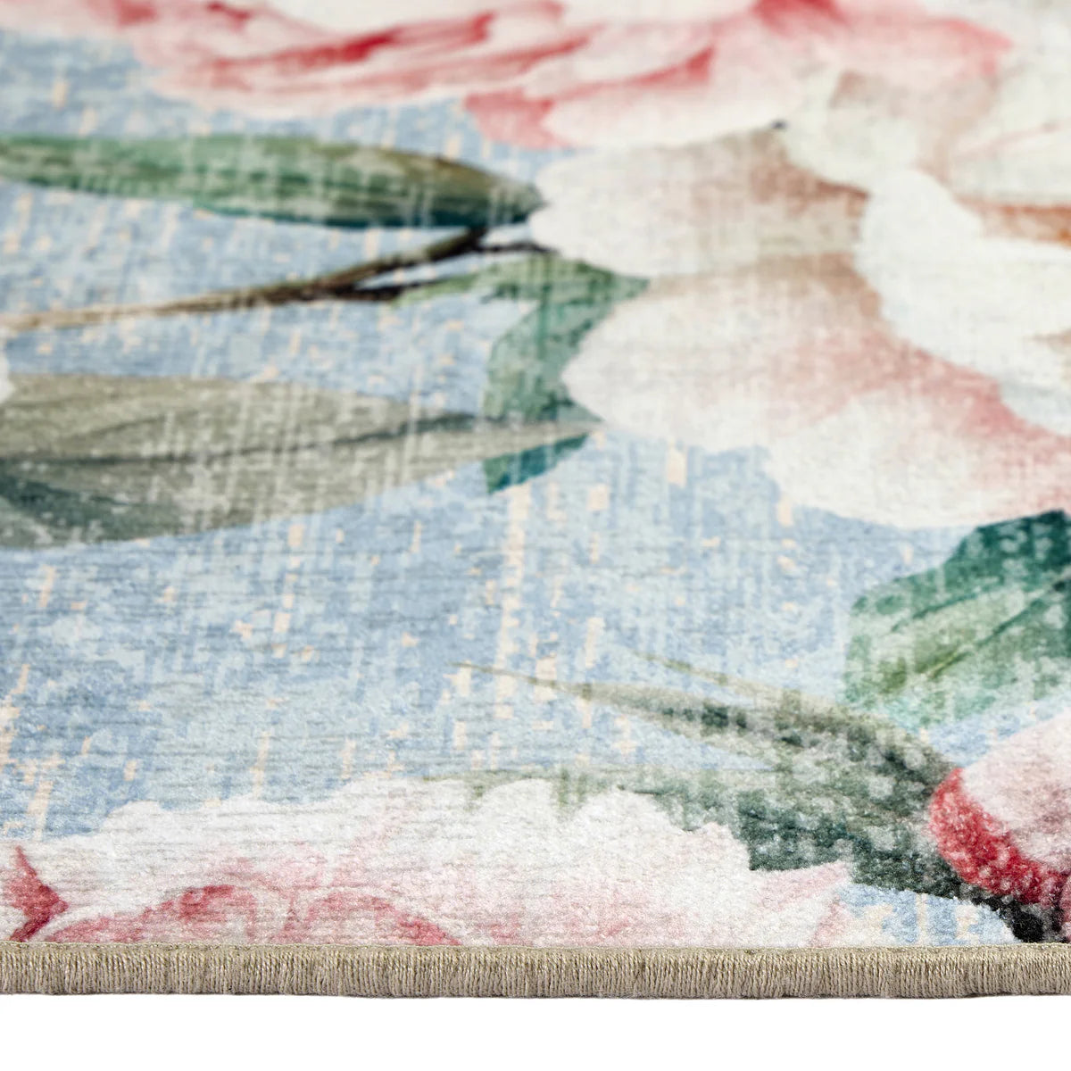 Close-up of a floral-patterned fabric with pink, white, and green flowers on a blue background.