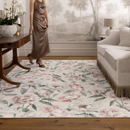 Living room with a floral rug, sofa, and decorative items.