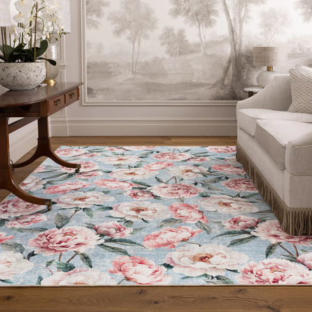 Floral patterned rug in a living room setting with a sofa and side table.