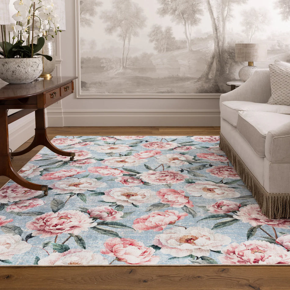 Floral patterned rug in a living room setting with a sofa and side table.