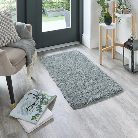 Blue Fleck rug on a wooden floor with a chair and books in the foreground