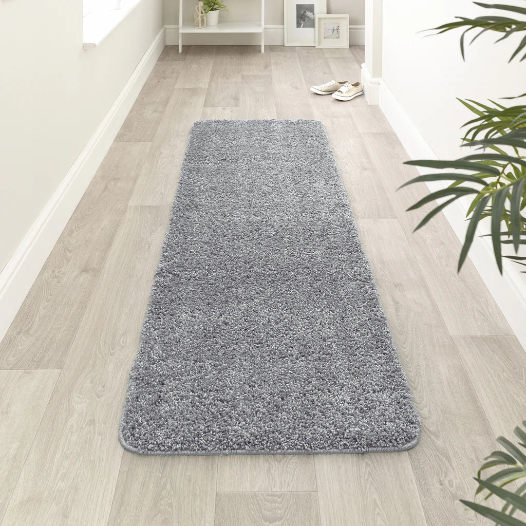 Blue Fleck runner rug on a wooden floor with a plant in the corner