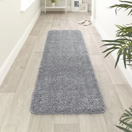 Blue Fleck runner rug on a wooden floor with a plant in the corner