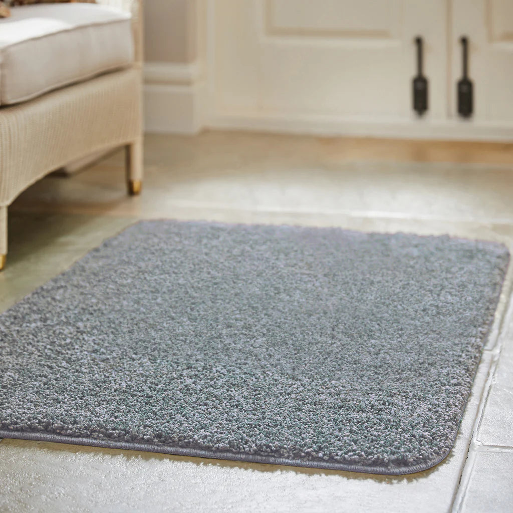 blue fleck rug on a wooden floor in a room with furniture.