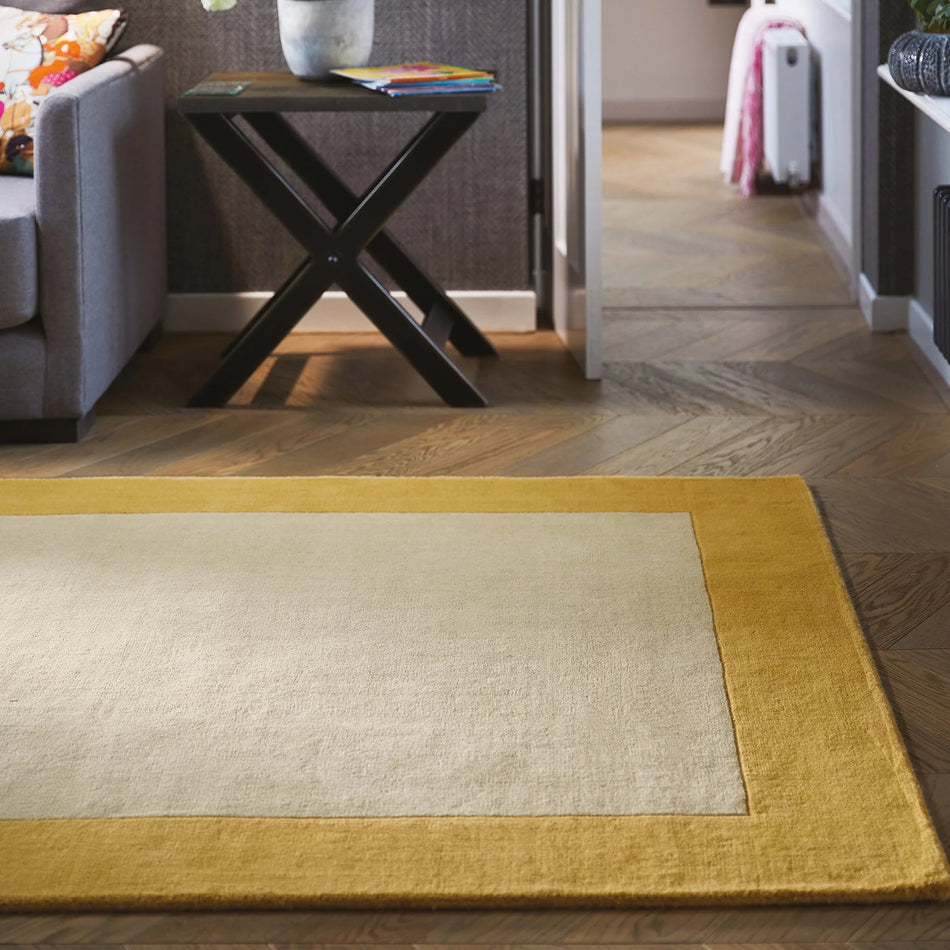 Hug Rug Origins Borders Ochre wool rug in lounge