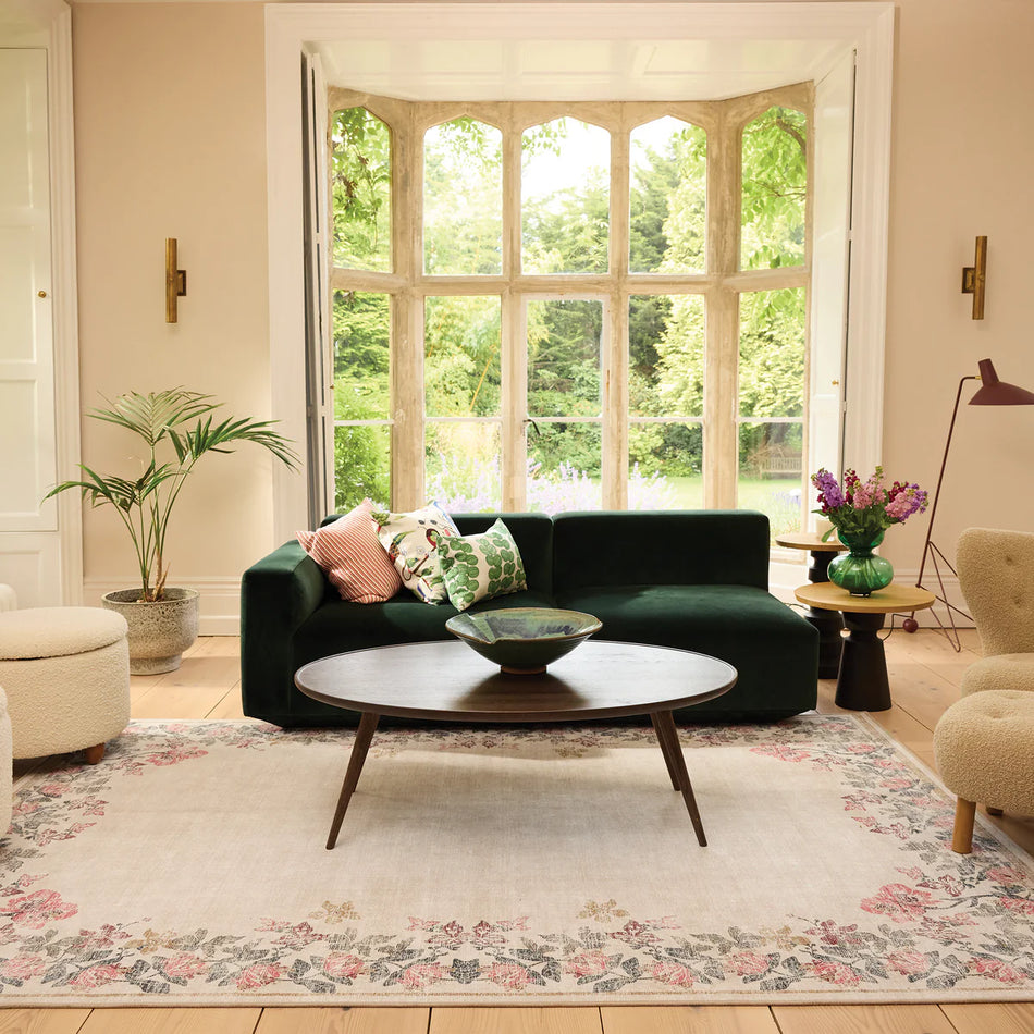 Modern living room with a green sofa, round coffee table, and decorative elements.