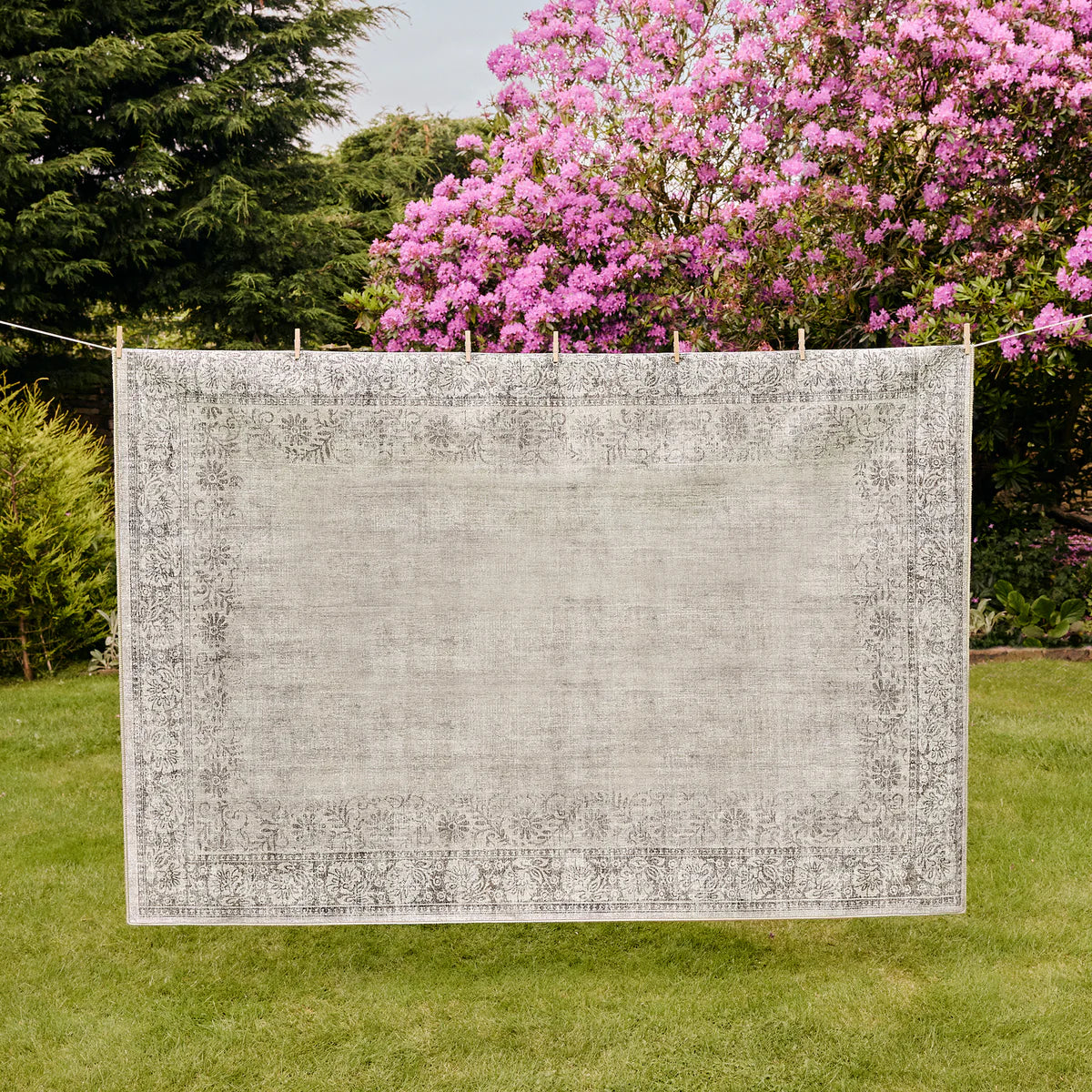 Textured white panel on a grassy area with pink flowering trees in the background