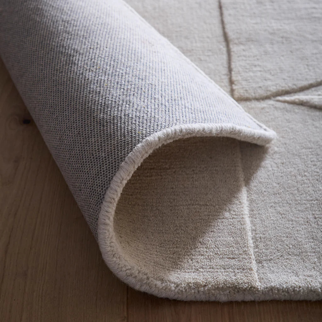 Close-up of a textured rug on a wooden floor