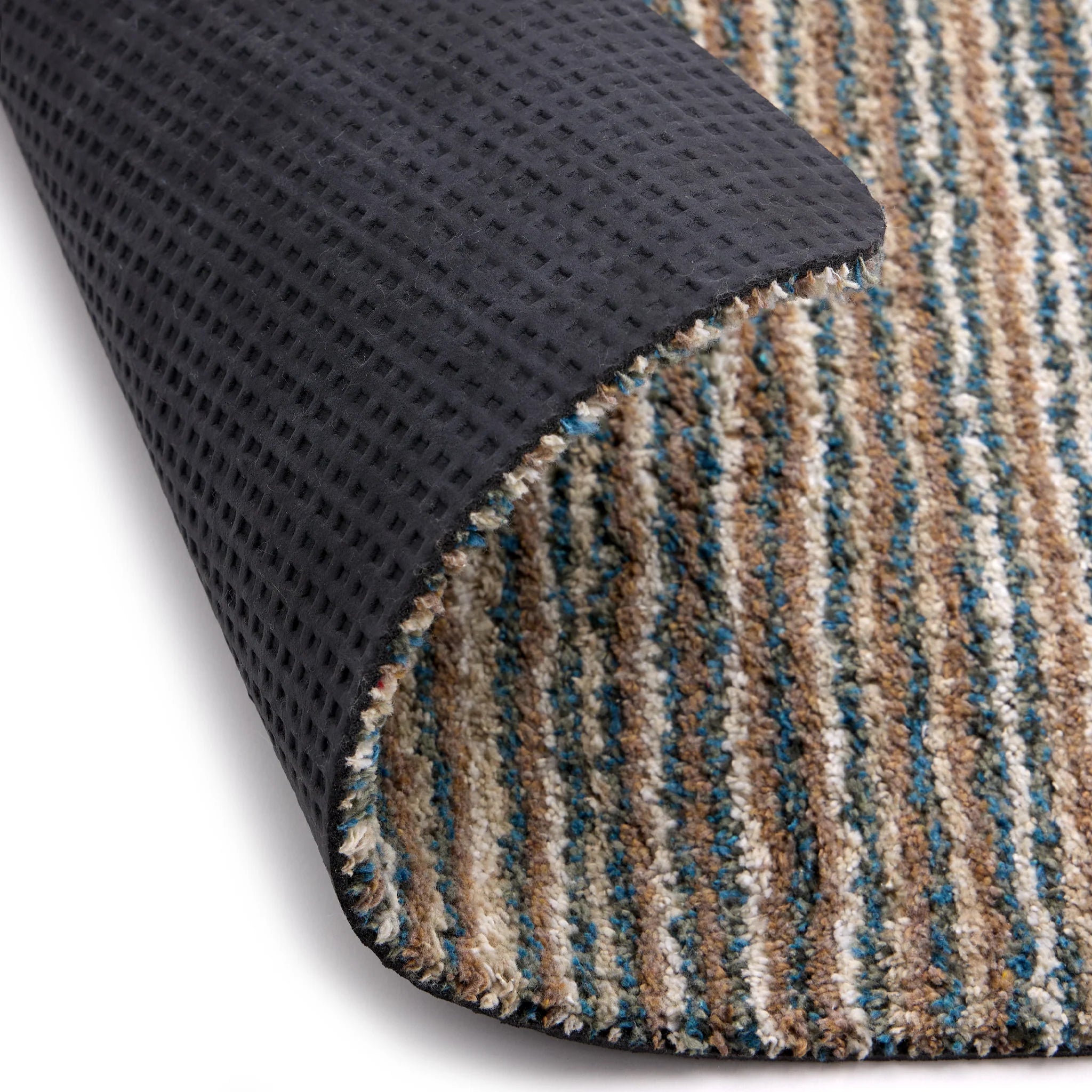 Close-up of a textured black mat and a striped multicolor rug corner.