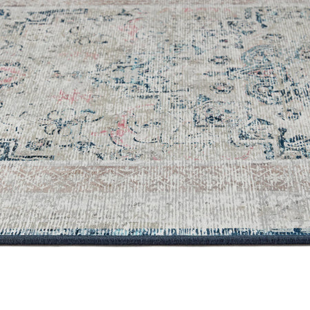 Close-up of a patterned rug with blue, pink, and gray colors.