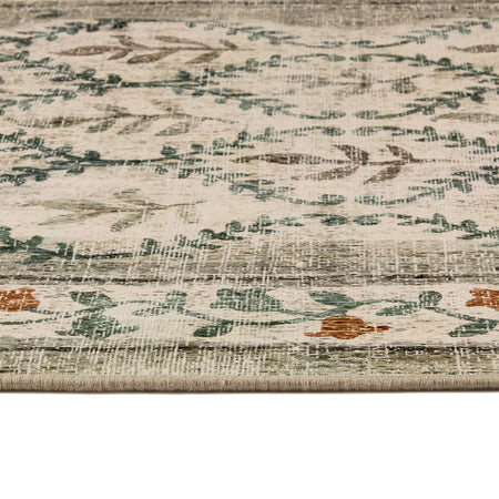 Close-up of a textured rug with floral patterns in beige, green, and brown.