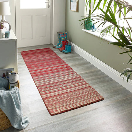 Origins Red striped runner on a wooden floor with a white door and plant in the background