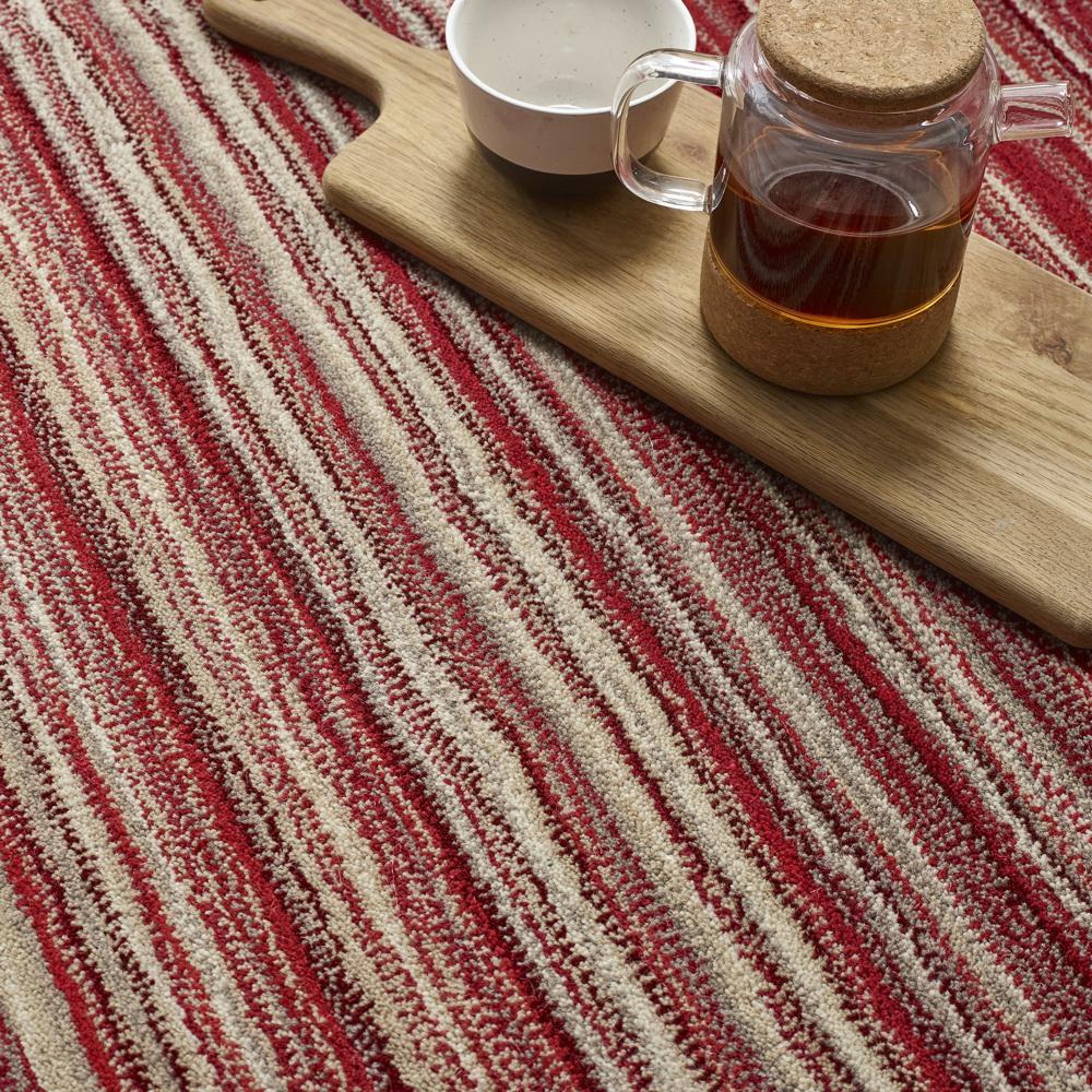 Glass jar with cork lid on a wooden cutting board over a Origins  red and beige striped fabric background