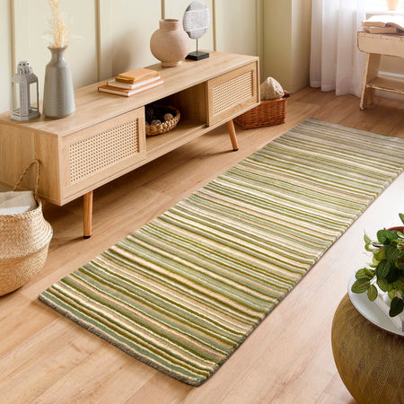 Living room with a wooden cabinet and a green striped rug on a light wood floor.
