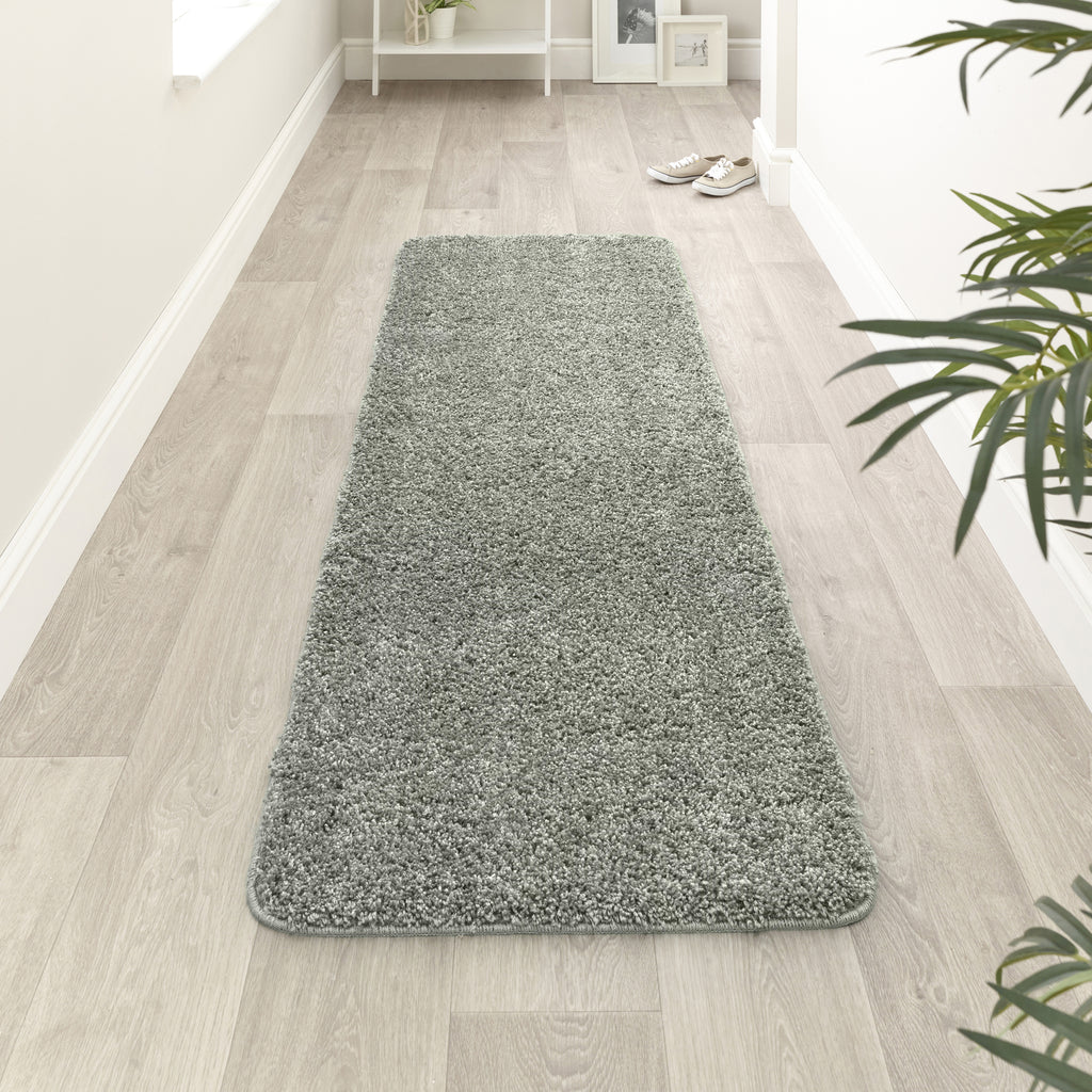 My Rug Green Fleck runner rug on a wooden floor with a plant in the corner