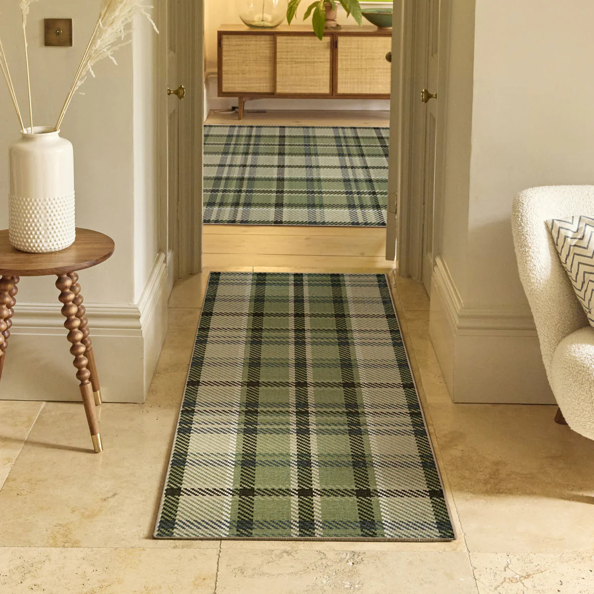 Plaid runner rug in a hallway with a side table and chair.