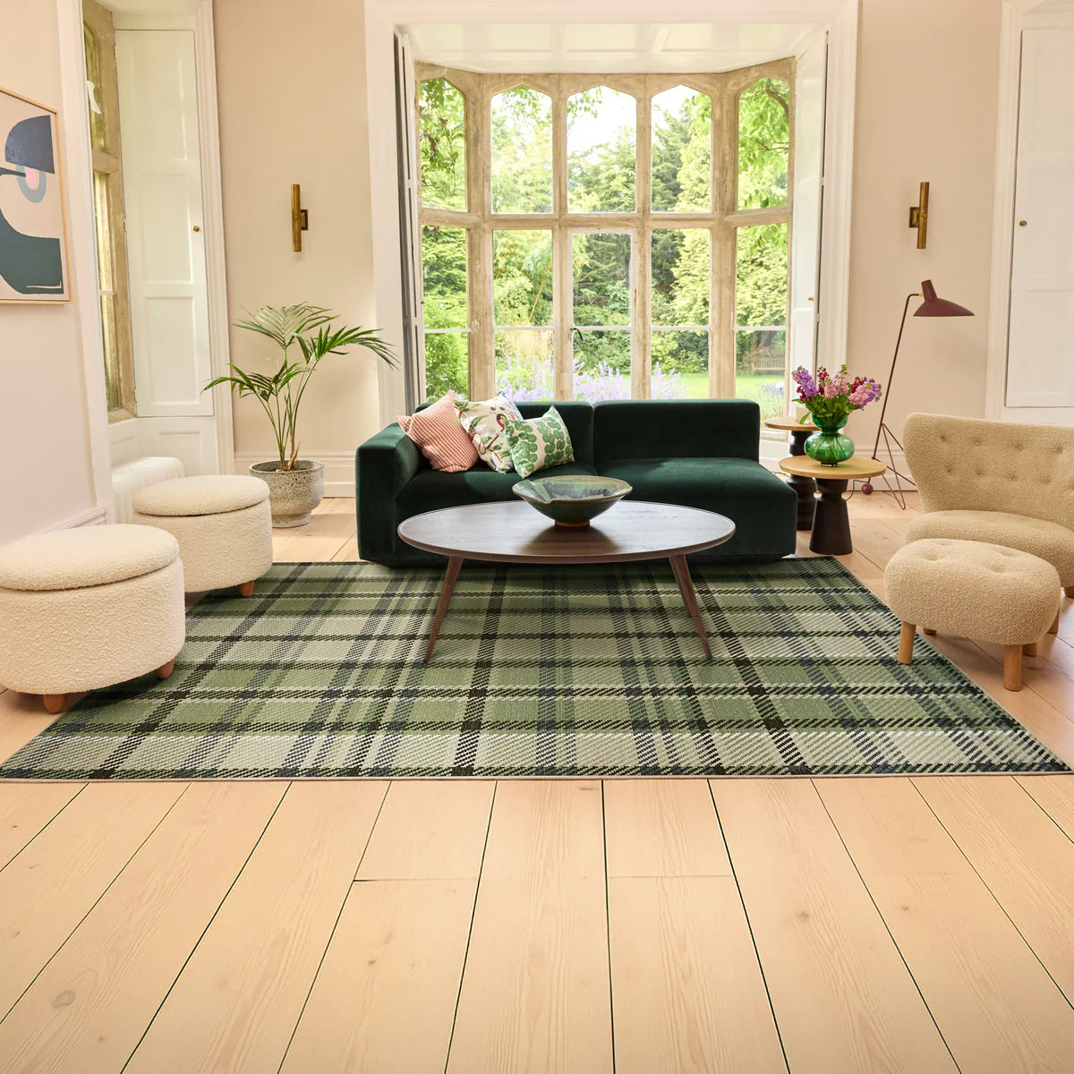 Living room with a green plaid rug, dark green sofa, and beige chairs.