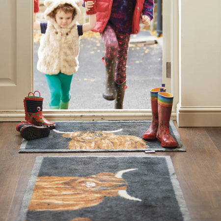 Hug Rug Highland Cow Barrier Mat placed in a cosy hallway, ideal for trapping dirt and moisture