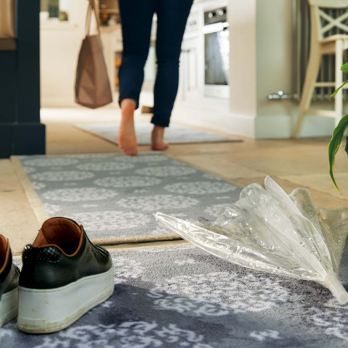 Person walking into a home with shoes on the rug