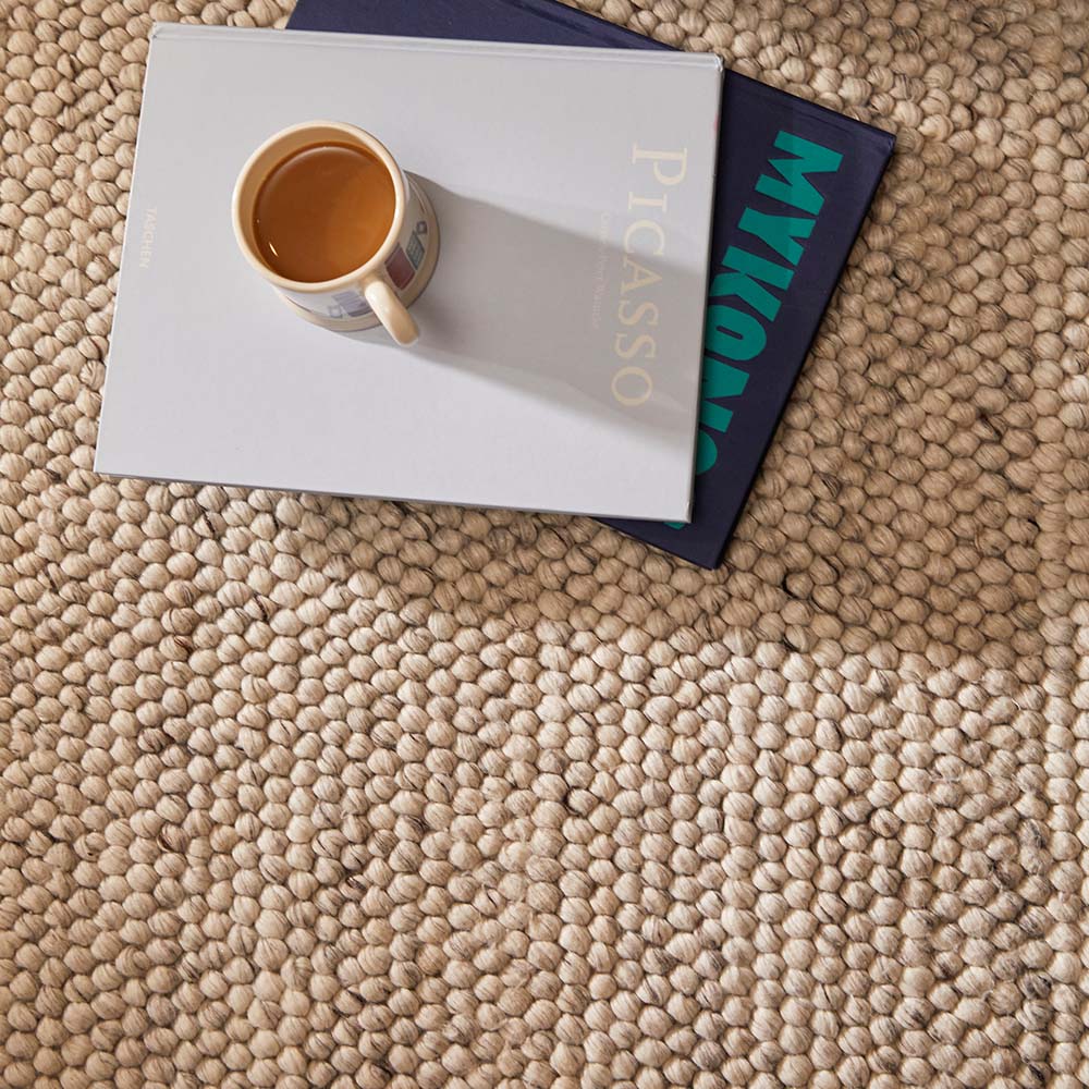 Cup of coffee on a book with 'Picasso' branding on a textured surface