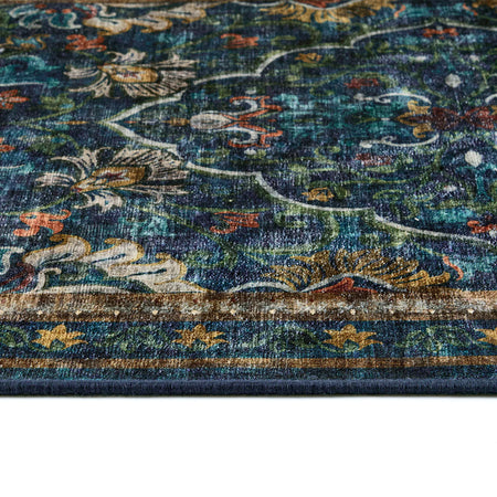 Close-up of a patterned rug with floral designs in blue, green, and brown.
