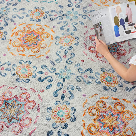 Person reading a magazine on a patterned rug