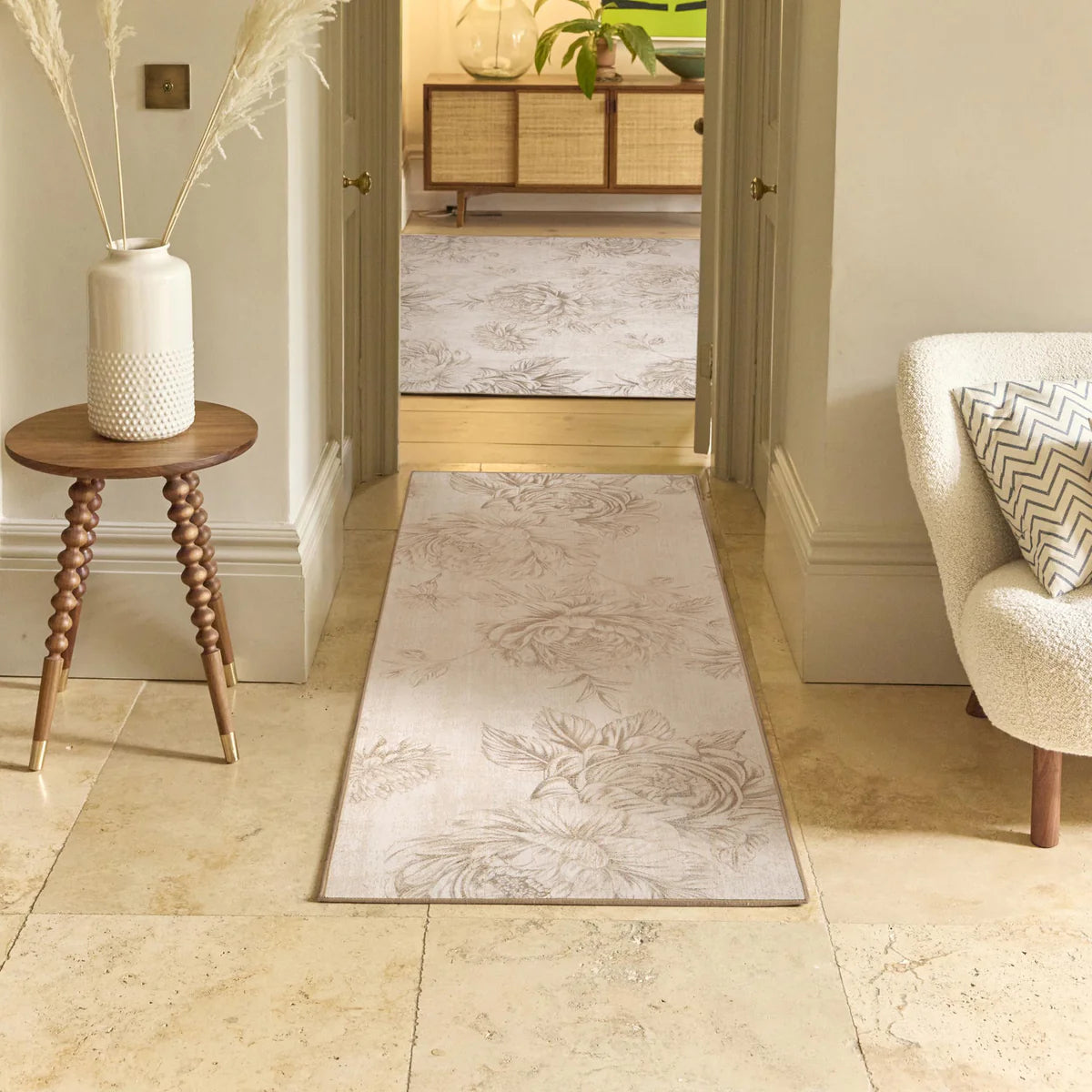 Decorative rug on a tiled floor with a side table and chair in a home setting.