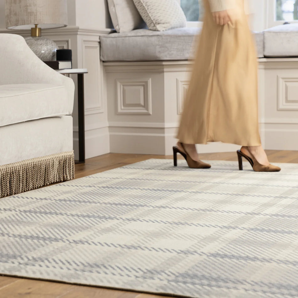 Person walking on a patterned rug in a living room setting