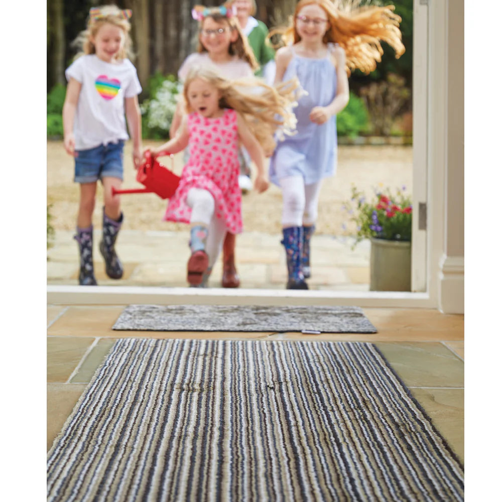 Children playing outside with a glass door in the foreground