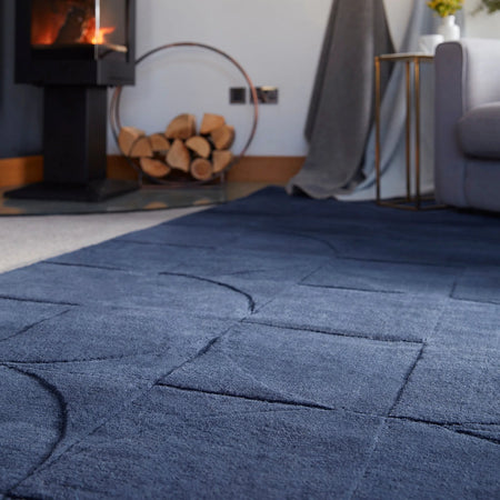 Blue textured rug in a living room with a fireplace and sofa.