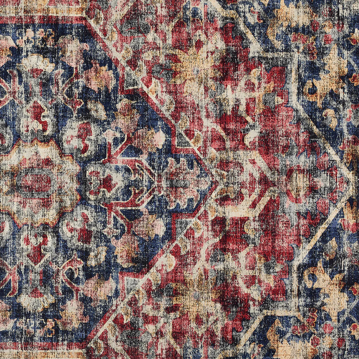 Close-up of a patterned rug with red, blue, and beige colors.