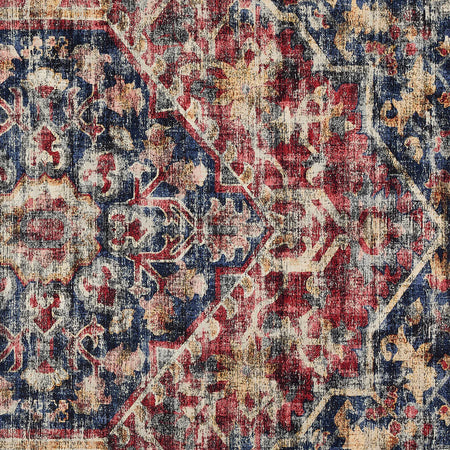 Close-up of a patterned rug with red, blue, and beige colors.