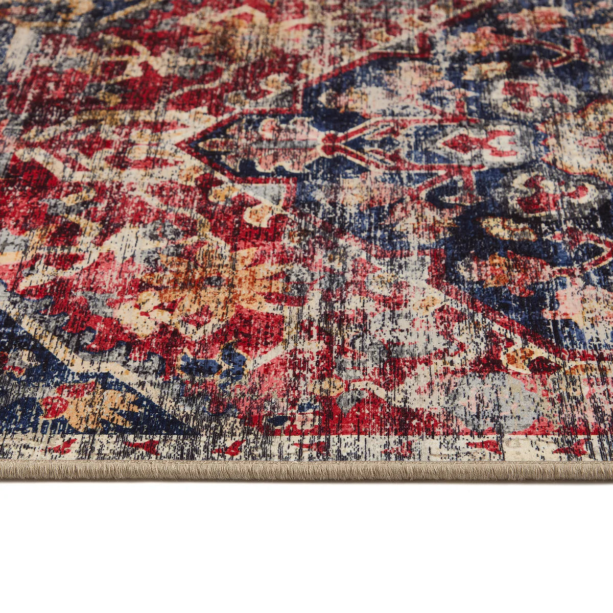 Close-up of a patterned rug with red, blue, and beige colors.