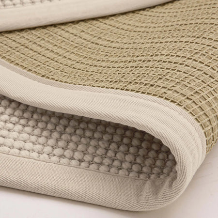 Close-up of textured fabric with waffle pattern on a light background