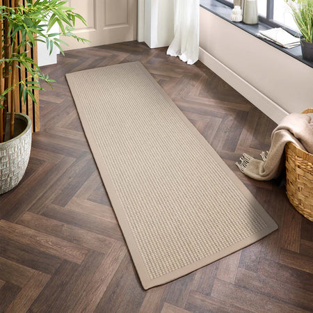 Sisal Boucle Beige runner rug on a wooden floor with plants and a basket in the background