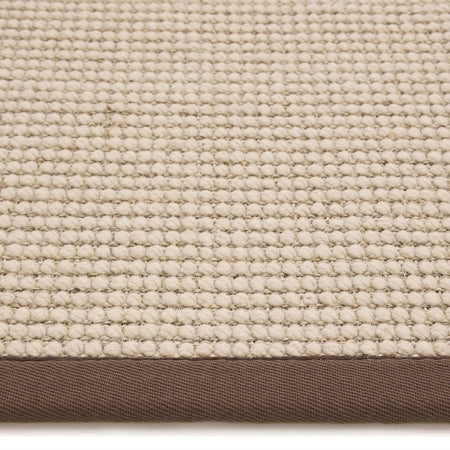 Close-up of a textured beige fabric with a brown border