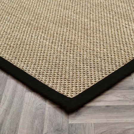 sisal Beige woven mat with a black border on a wooden floor