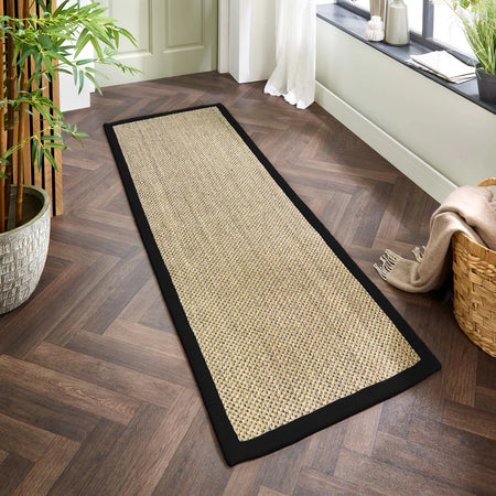 sisal Beige woven runner rug on a wooden floor with a window and plant in the background