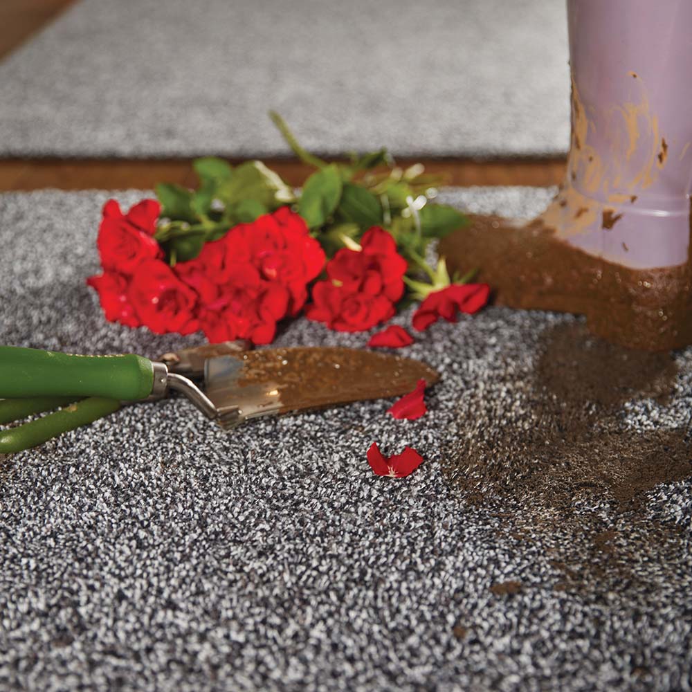 Red roses and a trowel on a textured surface with a blurred background