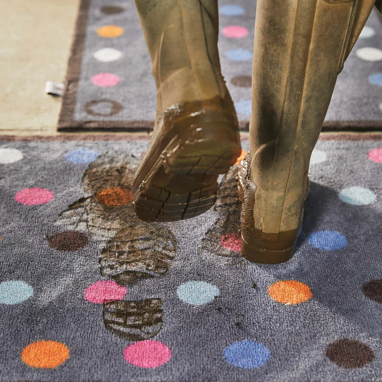 Person stepping onto a colorful polka dot rug with patterned border
