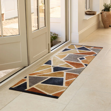 Geometric patterned rug on a tiled floor in a home entrance.