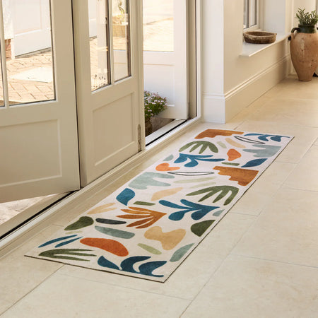 Colorful patterned rug on a tiled floor in a home setting