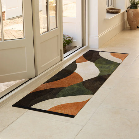 Decorative rug with abstract pattern on a tiled floor in a home setting.